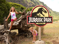 kids playing by the jurassic park sign at kualoa ranch in oahu hawaii